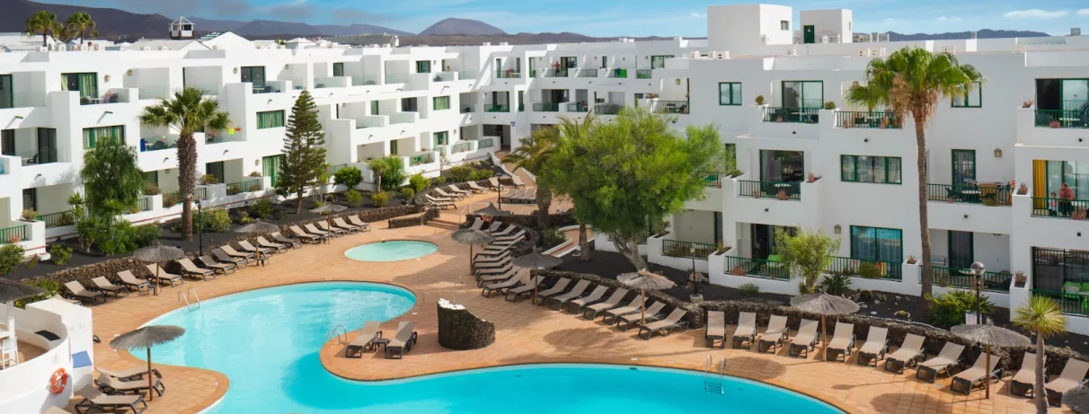 Une vue sur le complexe hôtelier, montrant la terrasses et la forme de la piscine.