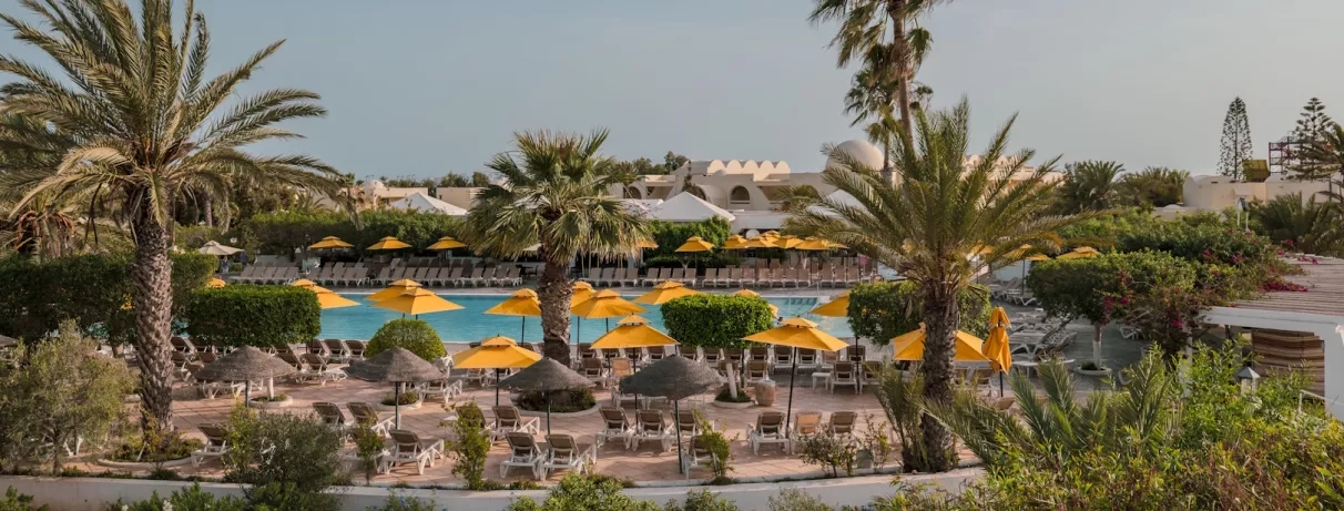 Vue panoramique sur les jardins, les palmiers et la piscine du Djerba Aqua Resort en Tunisie.