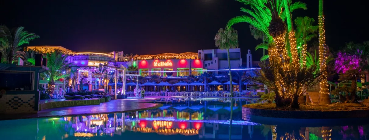 Illumination nocturne festive des piscines et restaurants de l'hôtel Welcome Meridiana pour une soirée vacances à Djerba.