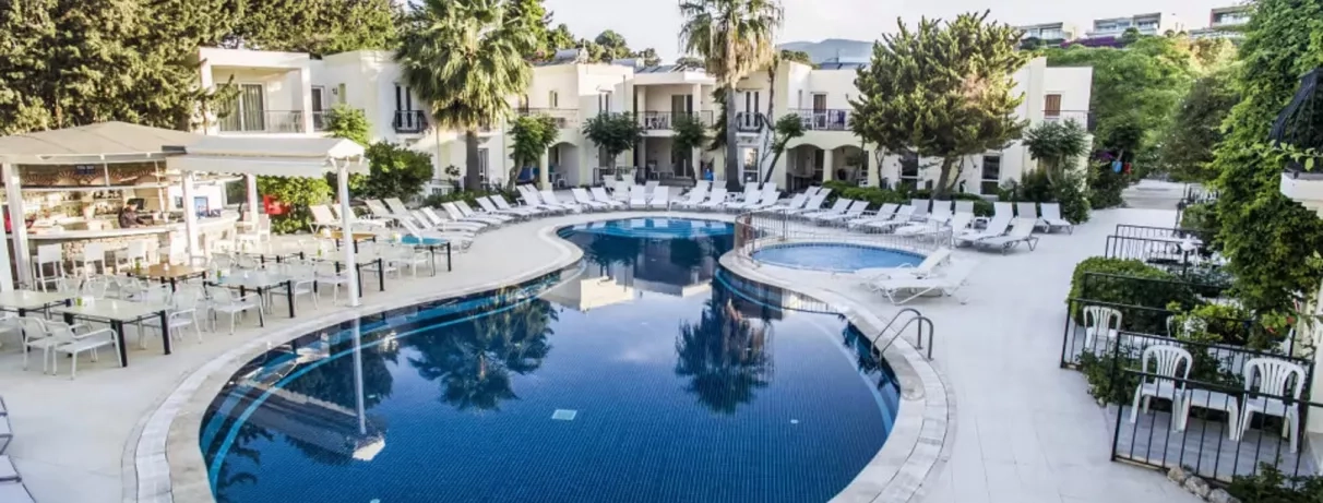 piscine extérieure avec transats et vue sur la façade de l'hôtel