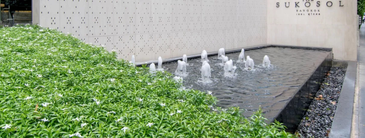 Un espace extérieur moderne avec une fontaine avec des jets d'eau alignés.