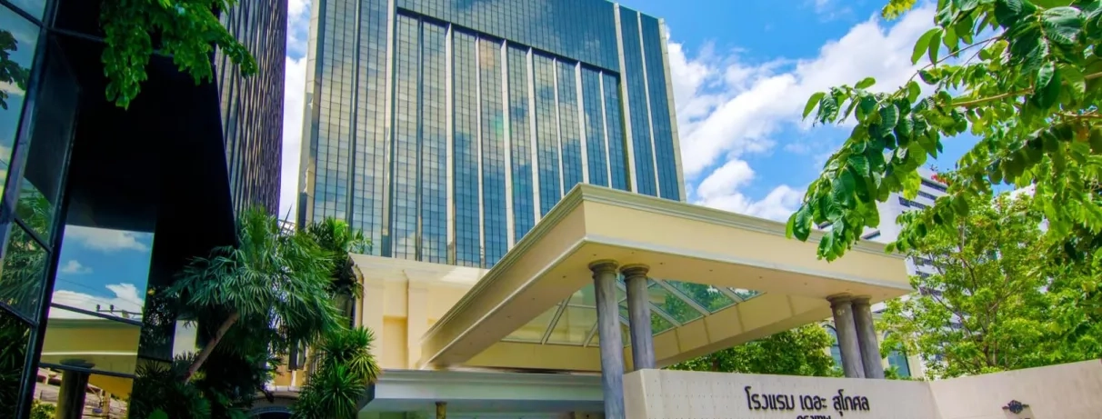 Vue de l'hôtel moderne avec une façade vitrée et une entrée abritée.