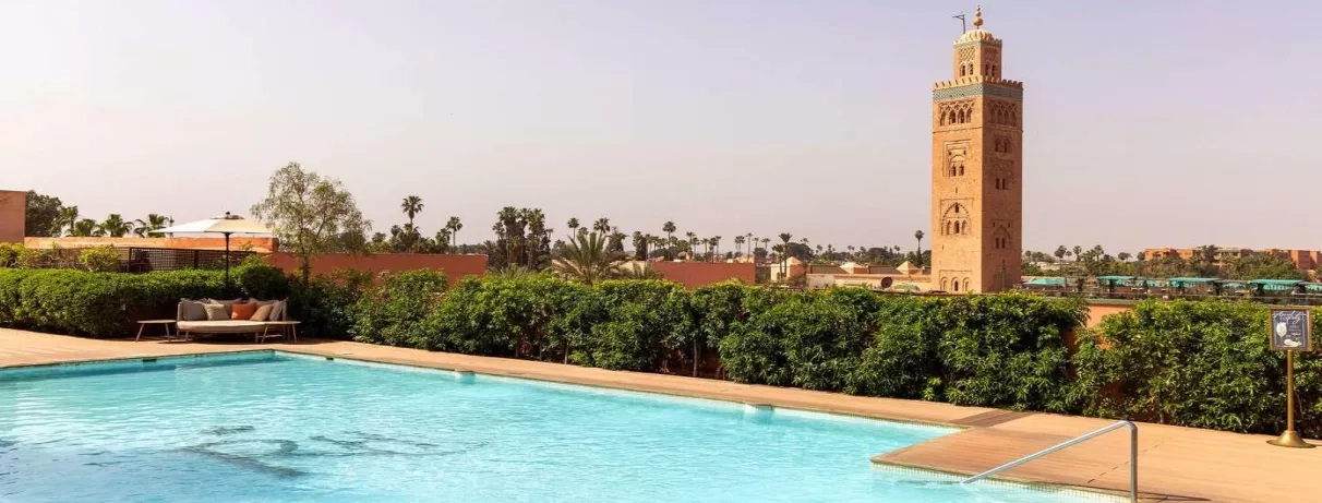 vue sur piscine extérieur de l'hôtel et la mosquée en pierre au milieu du ciel bleu 