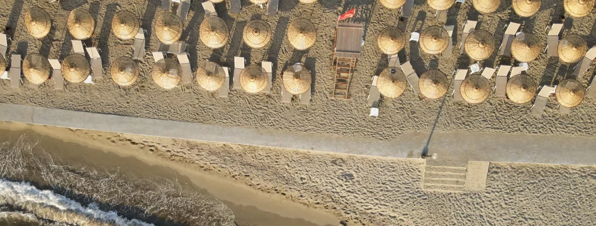 Un plan rapproché montrant des parasols de plage installés sur le sable.