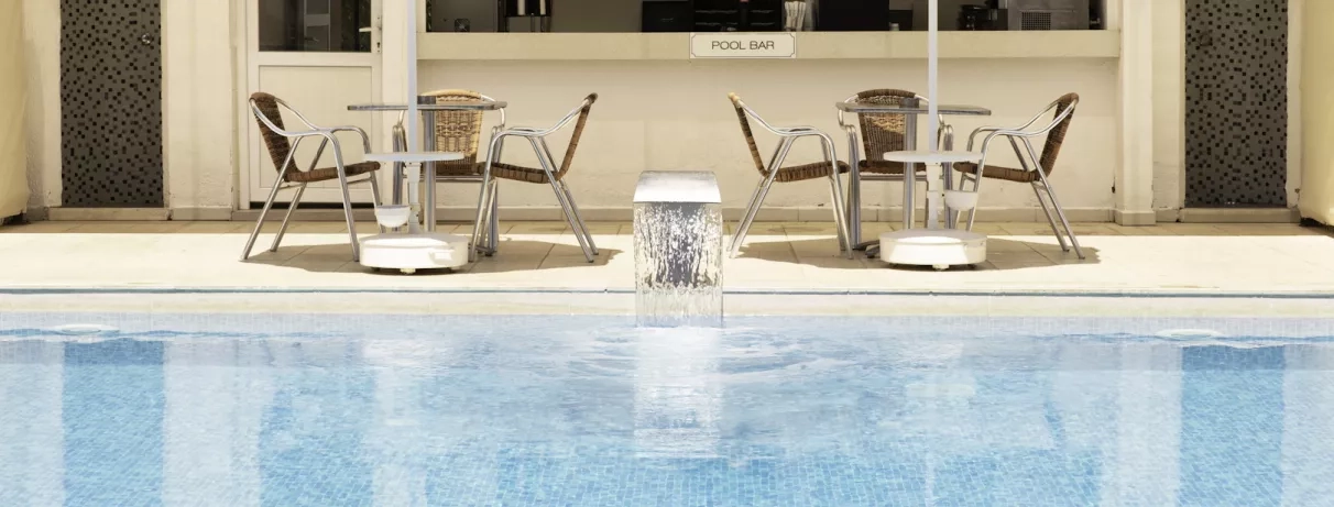 Un espace de détente paisible avec des tables et chaises installées au bord de l'eau.