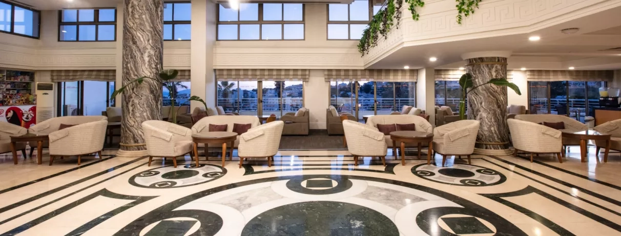 Un hall d'entrée luxueux et spacieux avec un sol en marbre et des colonnes imposantes.