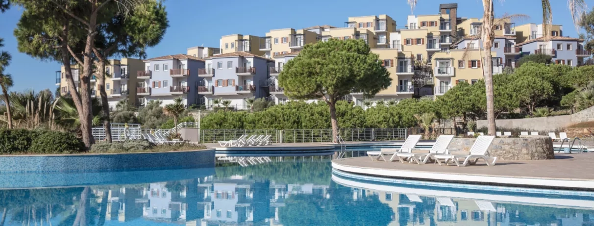 Une piscine étincelante avec des bâtiments modernes, sous un ciel bleu.