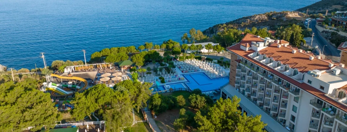 Un panorama ensoleillé montrant l'hôtel de bord de mer niché dans une végétation.