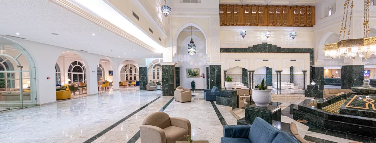 Hall de réception luxueux et spacieux du Djerba Golf avec colonnes en marbre et style oriental.