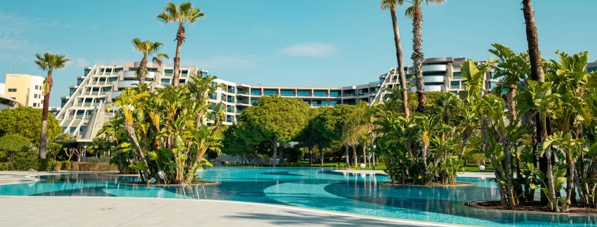 piscine extérieure avec des palmiers vue sur l'hôtel