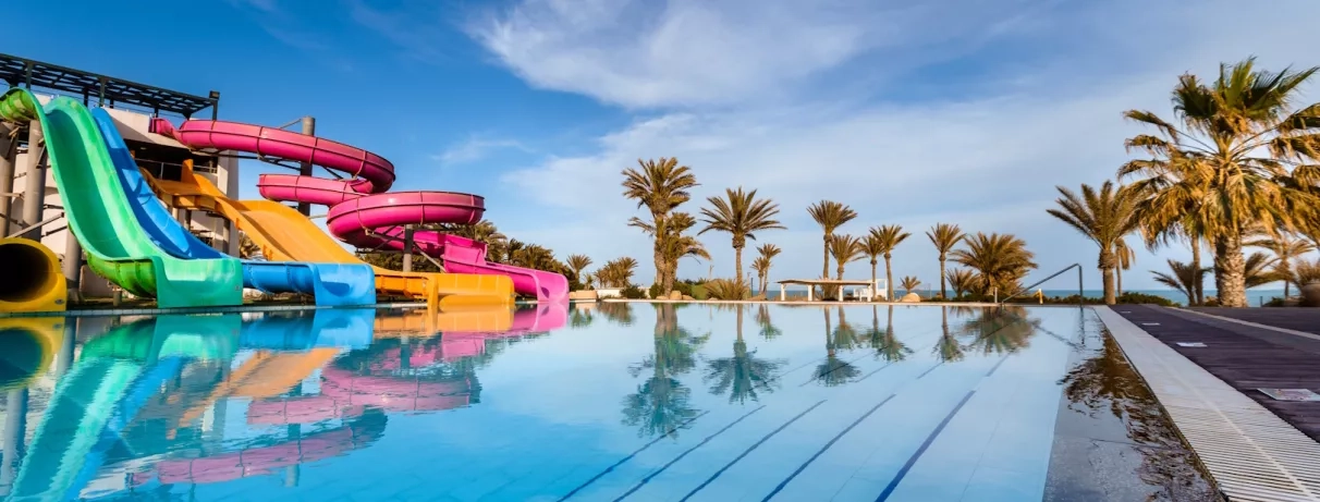 Parc aquatique avec toboggans colorés et piscine pour un séjour familial au Palm Azur Djerba.
