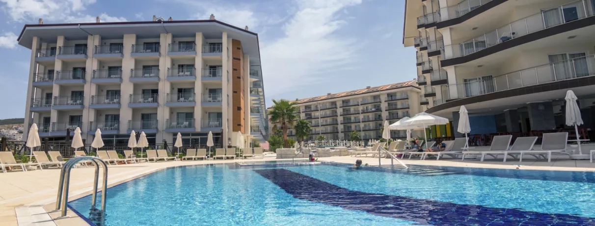 La piscine principale bordée de transats face aux bâtiments modernes de l'hôtel.