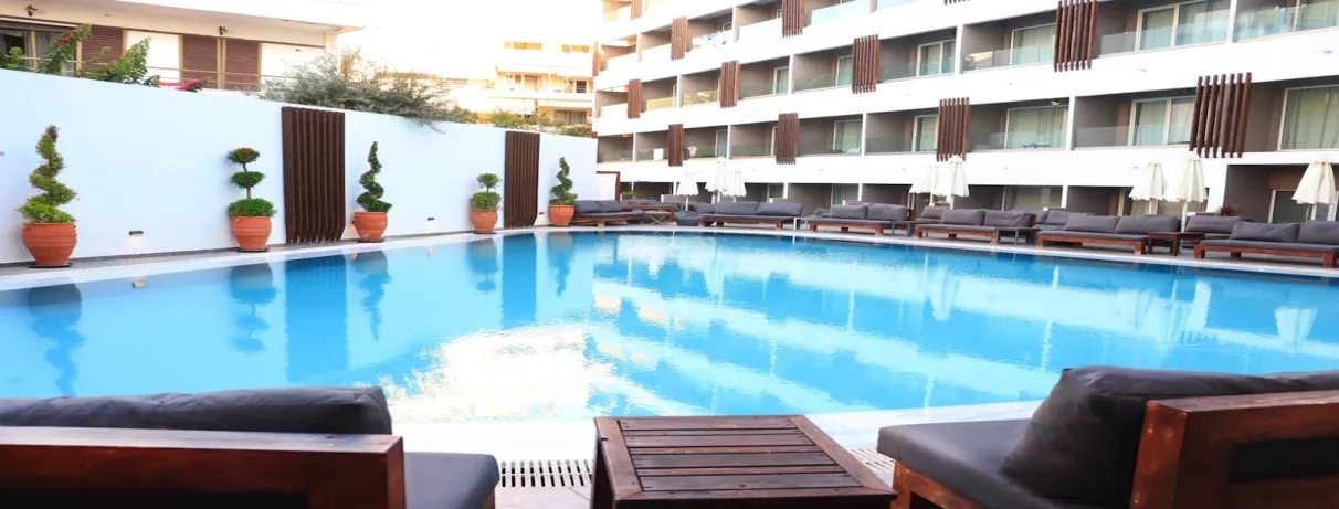 Vue piscine bâtiment de l'hôtel, terrasse, transats