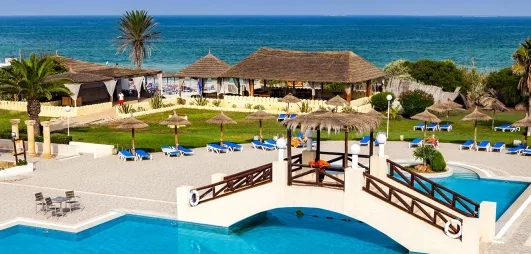 Piscine extérieure dotée d’un petit pont, offrant une vue dégagée sur la mer