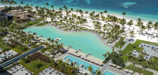 vue aérienne piscine et mer, eau turquoise, palmiers, hôtel, transat, sable blanc, végétation