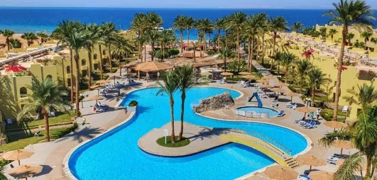 Vue de haut de la piscine avec toboggans, transats, parasols, vue sur mer