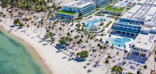 vue aérienne hôtel et plage, piscine, palmiers, eau turquoise, sable blanc, transats