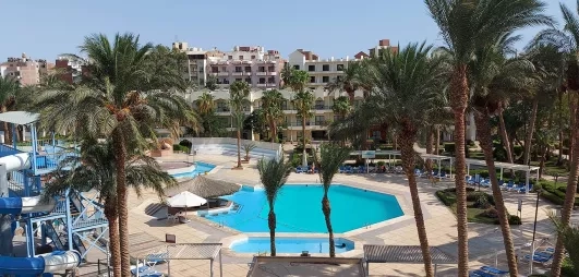 vue d'ensemble hôtel, grande et petite piscine extérieur, toboggans à gauche, palmiers, bâtiment de l'hôtel