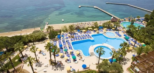 Une vue aérienne sur une grande piscine et un parc aquatique bordant la mer.