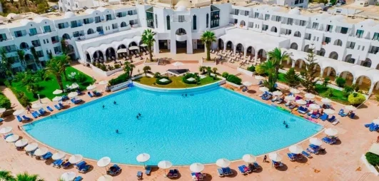 Grande piscine extérieure et architecture blanche typique de l'hôtel Palm Azur en Tunisie.