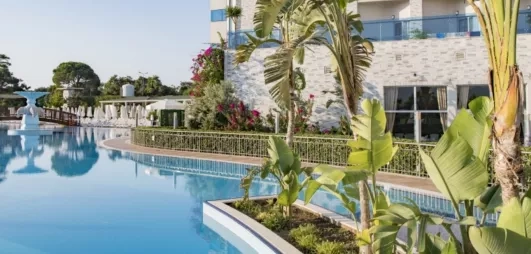 vue de la piscine extérieur et du jardin devant la façade de l'hôtel