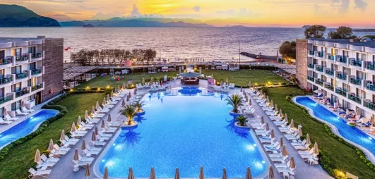 vue d'ensemble de l'hôtel avec piscine et mer avec un coucher de soleil