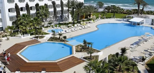 vue globale de l'hôtel englobant la grande piscine extérieure, une partie du bâtiment de l'hôtel et de la plage 