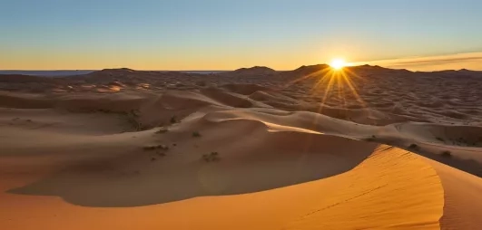 Le soleil se couche sur l'immensité des dunes du Sahara