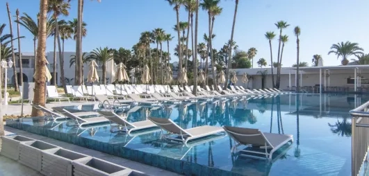 piscine extérieure avec transats et palmiers 