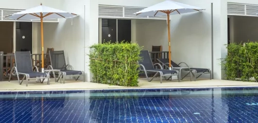 Des chambres en rez-de-chaussée avec terrasses donnant directement sur une piscine.