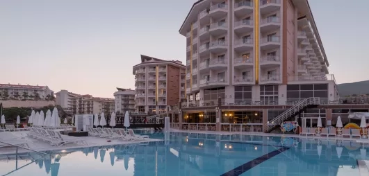 Un hôtel imposant surplombant une vaste piscine extérieure.