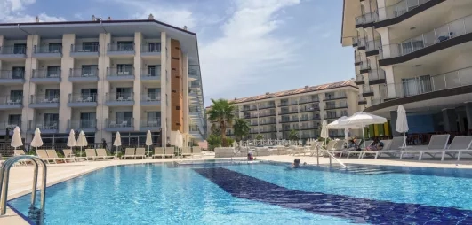 La piscine principale bordée de transats face aux bâtiments modernes de l'hôtel.