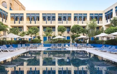 piscine extérieure équipée de transats et bâtiment de l'hôtel