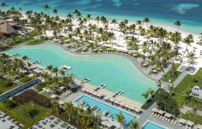 vue aérienne piscine et mer, eau turquoise, palmiers, hôtel, transat, sable blanc, végétation