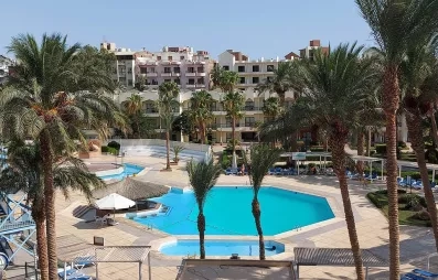 vue d'ensemble hôtel, grande et petite piscine extérieur, toboggans à gauche, palmiers, bâtiment de l'hôtel