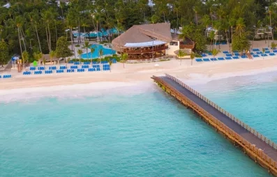 Plage avec ponton, sable, eau claire, transats bleus, plusieurs piscines, végétation