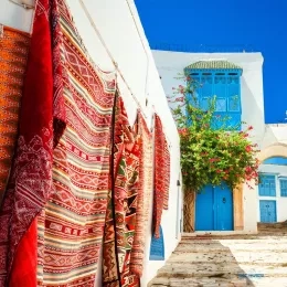 Maison blanche avec fenêtre bleue et tapis