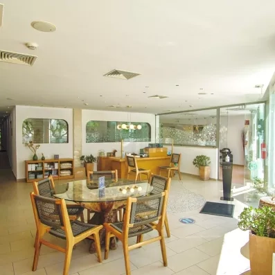 salle de petit-déjeuner de l'hôtel avec des chaises en bois et des tables rondes en verre