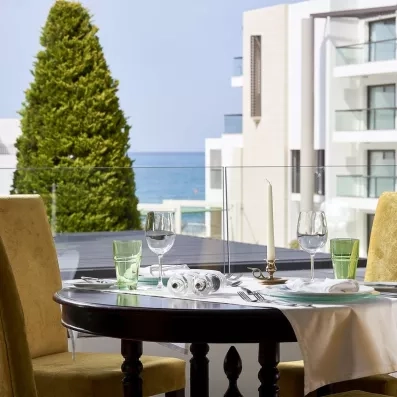table  de restaurant sur la terrasse bien dressée, donnant sur une vue mer