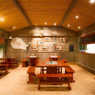 Salle de restaurant rustique décorée de trophées de chasse typiques de la culture boréale en Finlande.