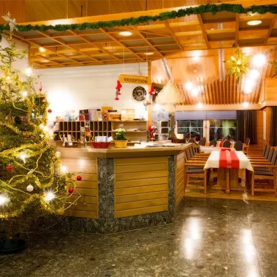 Réception chaleureuse de l'hôtel Samperin Savotta décorée pour Noël lors d'un séjour hivernal en Laponie.