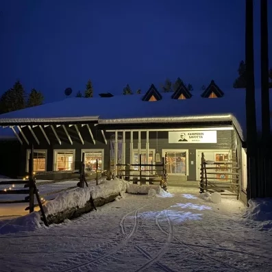 Façade illuminée de l'hôtel Samperin Savotta sous la nuit polaire enneigée lors d'un voyage en Finlande.