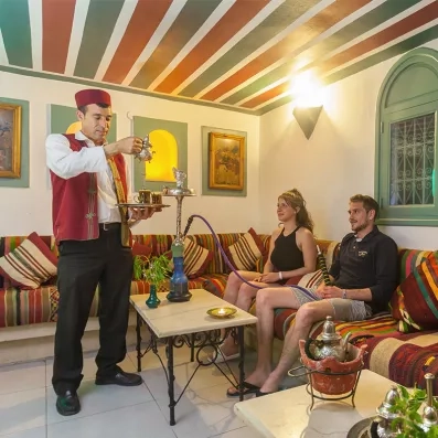 Ambiance salon de thé traditionnel tunisien au Djerba Aqua Resort avec service de thé à la menthe.
