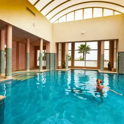 Piscine intérieure de l’hôtel, où une personne profite paisiblement de l’espace aquatique