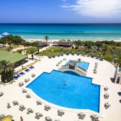 vue aérienne de la piscine extérieure équipée de transats et de la mer en fond 