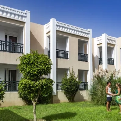 bâtiment de l'hôtel avec deux personnes se tenant les mains dans l'herbe 