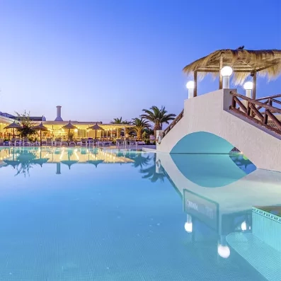 Piscine extérieure dotée d'un pont pour traverser, éclairée par des lampadaires