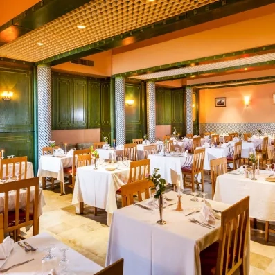 Restaurant chaleureux aux tables dressées, décor boisé et éclairage doux