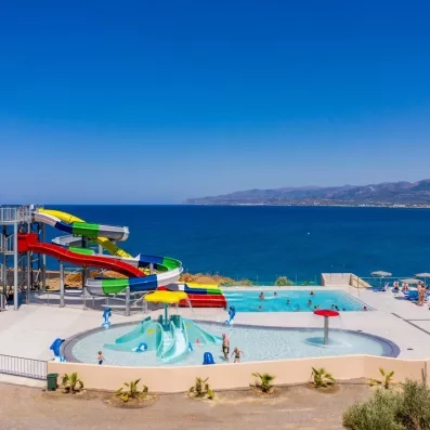 piscine avec toboggans coloré et piscine enfant, vue sur plage, été et soleil