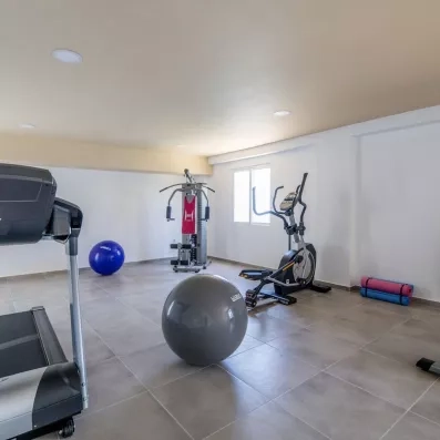 salle de fitness équipé de bicyclette, tapis, et des ballons gonflables 